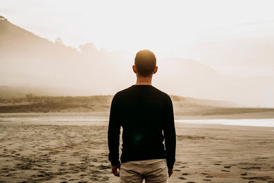 Rear view of man standing on beach