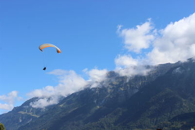 Low angle view of paragliding against sky