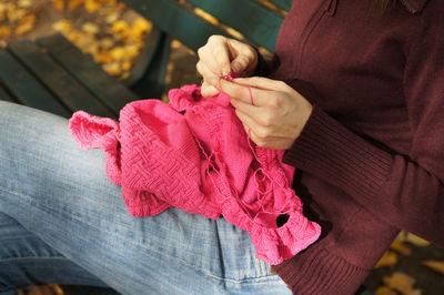 Midsection of woman holding pink umbrella during winter