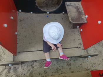 High angle view of baby girl sitting at playground