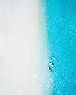 People in sea against blue sky