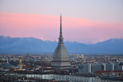 Buildings in city against sky during sunset