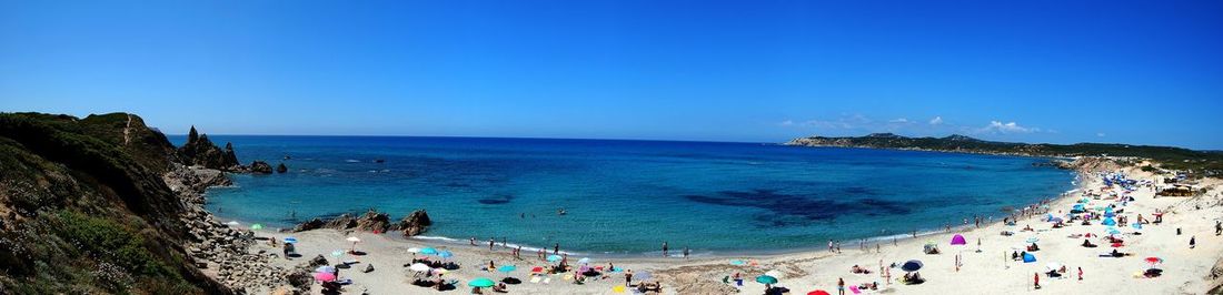 People on beach against blue sky