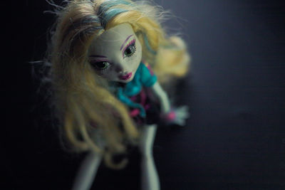 Close-up of doll on black background