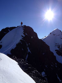 Person on snowcapped mountain against sky