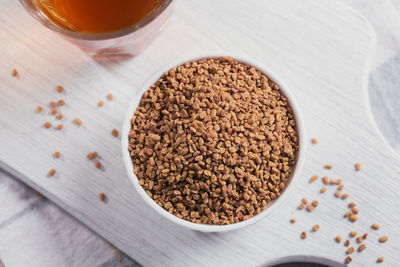 Bowl of fenugreek seeds and egyptian fenugreek yellow tea or methi dana drink