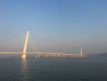 Suspension bridge over sea against sky