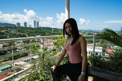 Full length of young woman standing against sky