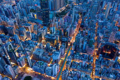 Aerial view of buildings in city against sky at dusk