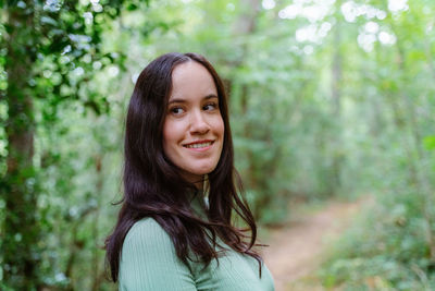 Portrait of a smiling young woman in forest