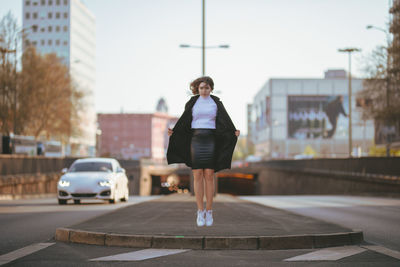 Full length of woman on road in city