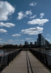 Footpath amidst buildings against sky