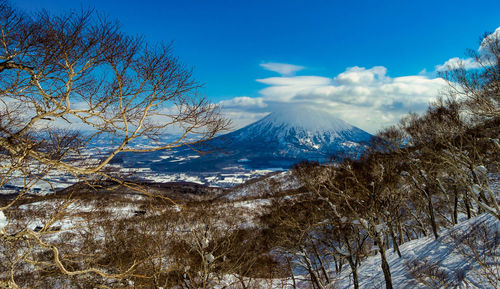 Scenic view of snowcapped mountains against blue sky