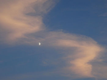 Low angle view of moon in sky at sunset
