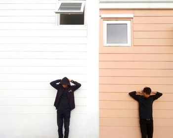 Full length of woman standing against wall