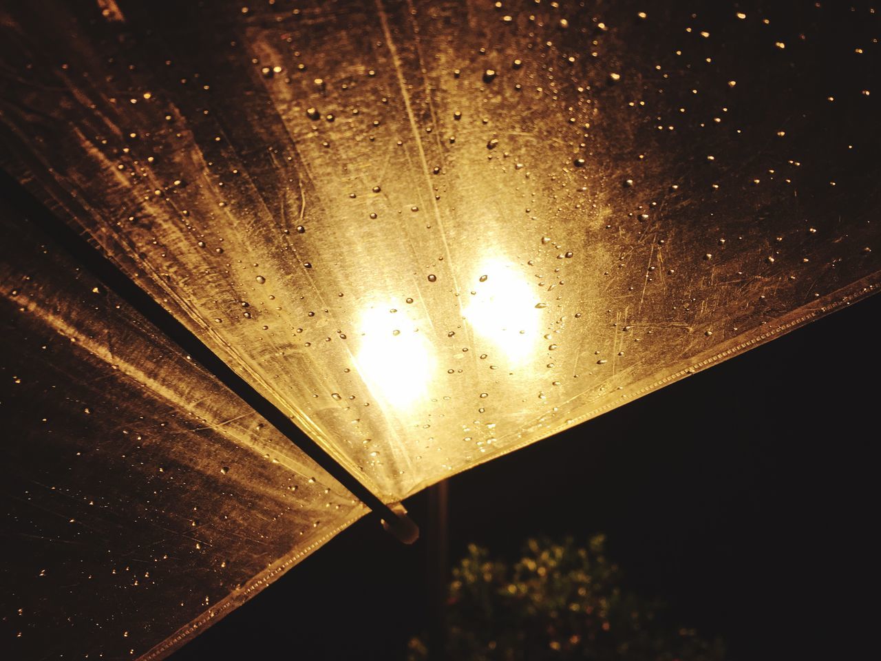 indoors, glass - material, window, transparent, illuminated, drop, night, wet, close-up, glass, rain, water, dark, lighting equipment, raindrop, focus on foreground, season, no people, light - natural phenomenon, sky