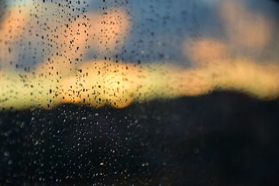 Close-up of wet glass window during rainy season