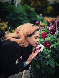 Midsection of woman standing by flowering plants