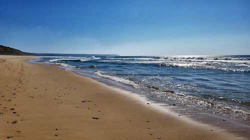 Scenic view of beach against blue sky