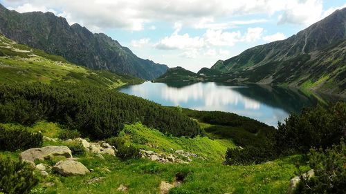 Scenic view of lake by mountains against sky