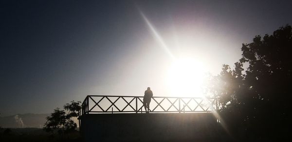 Low angle view of silhouette person standing against clear sky