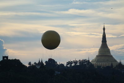 Low angle view of balloons against sky during sunset