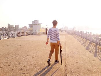 Full length rear view of woman against clear sky