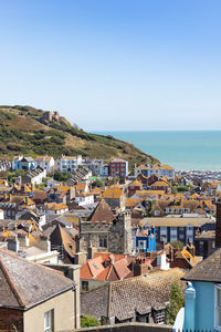 High angle view of townscape by sea against clear sky