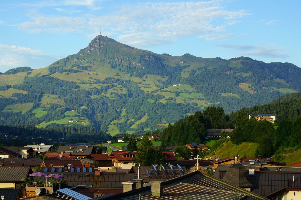 mountain, mountain range, tree, sky, scenics, building exterior, day, architecture, built structure, outdoors, nature, house, beauty in nature, cloud - sky, town, tranquil scene, tranquility, no people, roof, growth, landscape