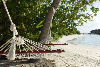 Metallic structure on beach against sky