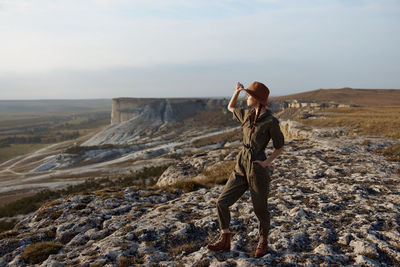Rear view of man standing on mountain against sky
