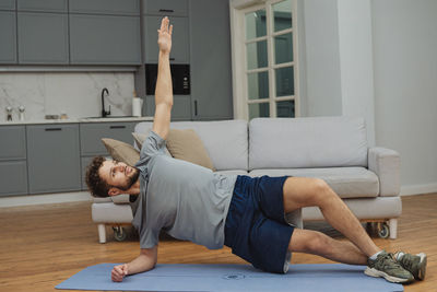 Boy playing with toy while sitting on sofa at home