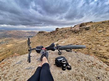 Man riding bicycle on mountain against sky