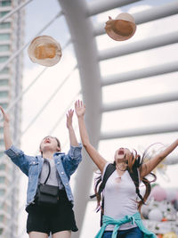 Cheerful females throwing hats