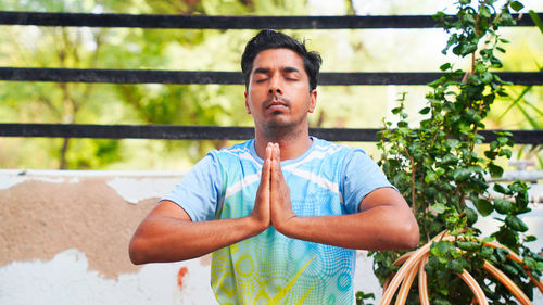 Healthy man sitting on mat and meditation with lotus pose in morning. wellness, fitness, exercise a