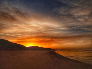 Scenic view of beach against sky during sunset