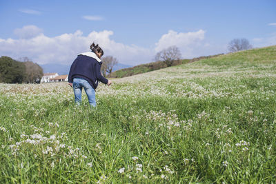 Woman standing on field against sky