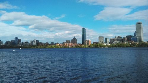 River by cityscape against sky