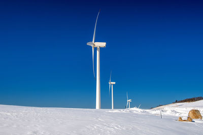 Low angle view windmill on field against sky during winter