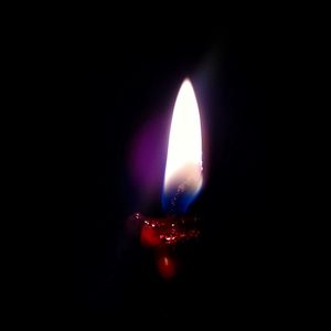 Close-up of illuminated light candle against black background