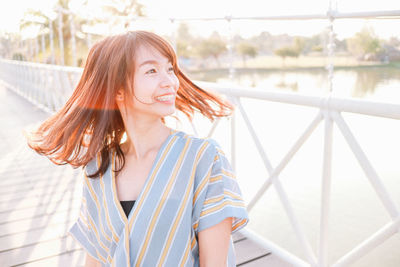 Portrait of beautiful woman against railing