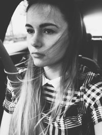 Close-up portrait of young woman in car