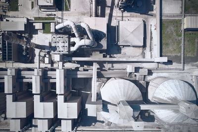 Top down aerial view of huge cement producing factory. pipes, silos and other structures