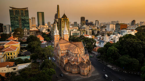 High angle view of church against buildings in city at sunset