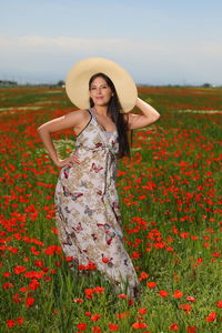 Portrait of beautiful woman standing on field