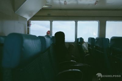 Rear view of man sitting in train