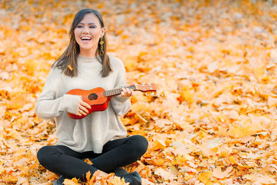 Portrait of young woman sitting on field