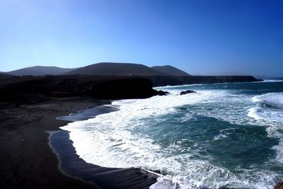 Scenic view of sea against clear blue sky