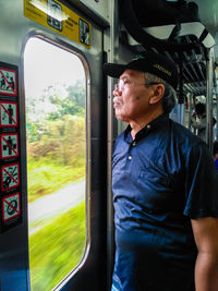 Side view of man looking away in train
