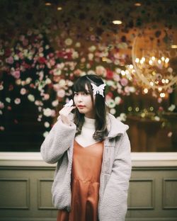 Young woman looking away while standing outdoors